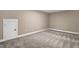 Finished basement space with neutral paint, carpeting, and a white door to a storage area at 1119 Brookfield Dr, Gibsonville, NC 27249