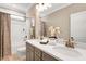 Bathroom with double sinks, quartz counters, and a shower-tub combo at 1119 Brookfield Dr, Gibsonville, NC 27249