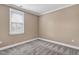 Spare bedroom with neutral colored walls, carpeting, and window with blinds overlooking the yard at 1119 Brookfield Dr, Gibsonville, NC 27249