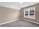 Spare bedroom with neutral walls, carpeting, and window overlooking mature trees and greenery at 1119 Brookfield Dr, Gibsonville, NC 27249