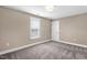 Neutral colored room with carpet, one window, and white trimming and baseboards on the walls at 1119 Brookfield Dr, Gibsonville, NC 27249