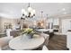 Bright dining area adjacent to the kitchen and living room, featuring a modern chandelier at 1119 Brookfield Dr, Gibsonville, NC 27249
