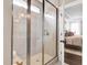 Beautiful walk-in shower with glass door and wall and a view into the well-lit main bedroom at 1119 Brookfield Dr, Gibsonville, NC 27249