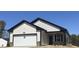 New construction home showcasing light siding, black trim, a two-car garage, and an inviting front entrance at 11198 Salers Loop, Middlesex, NC 27557