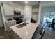 Bright kitchen featuring a quartz countertop island with sink, stainless steel appliances, and eat in dining area at 11198 Salers Loop, Middlesex, NC 27557