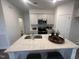 Bright kitchen with quartz countertop island, stainless appliances, and grey shaker cabinets at 11198 Salers Loop, Middlesex, NC 27557