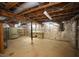 Unfinished basement with refrigerator, shelving, work bench, exposed wood rafters, and foil insulation at 116 Trinity Woods Dr, Raleigh, NC 27607