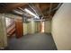 Unfinished basement with drop ceiling, wood paneled walls, concrete block walls, and gray carpeted floor at 116 Trinity Woods Dr, Raleigh, NC 27607
