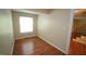 Cozy bedroom with hardwood floors, a window, and access to a staircase at 116 Trinity Woods Dr, Raleigh, NC 27607