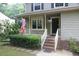 Inviting front porch with brick steps, lush hedges, and an American flag at 116 Trinity Woods Dr, Raleigh, NC 27607