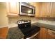 Close up of modern kitchen appliances, granite counters, and sleek cabinetry at 116 Trinity Woods Dr, Raleigh, NC 27607