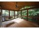Screened in porch with wood flooring, ceiling fan, and hanging bench swing at 116 Trinity Woods Dr, Raleigh, NC 27607