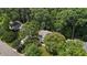 An aerial view features lush greenery and mature trees surrounding the property at 1210 Eastham Dr, Apex, NC 27502