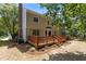 Backyard of the home featuring a wooden deck, chimney, and shaded lawn at 1210 Eastham Dr, Apex, NC 27502