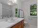 Inviting bathroom with a classic vanity, a window, and a glass-enclosed shower for a blend of style and comfort at 1210 Eastham Dr, Apex, NC 27502