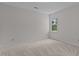 Clean bedroom featuring neutral carpet, a single window, and light walls, creating a simple yet comforting space at 1210 Eastham Dr, Apex, NC 27502