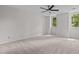 Spacious bedroom with neutral carpet, ceiling fan, and large windows at 1210 Eastham Dr, Apex, NC 27502