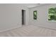 Bright bedroom with neutral carpet, two windows, closet, and light walls, creating a peaceful space at 1210 Eastham Dr, Apex, NC 27502