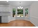 Bright breakfast nook featuring a bay window overlooking a wooded backyard and a modern chandelier at 1210 Eastham Dr, Apex, NC 27502
