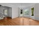 Elegant dining room with hardwood floors, large windows, a chandelier, and access to the hallway and staircase at 1210 Eastham Dr, Apex, NC 27502