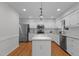 Bright kitchen with white cabinets, stainless steel appliances and a stone topped island at 1210 Eastham Dr, Apex, NC 27502