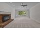 Bright living room boasts a brick fireplace, large window, and neutral carpet at 1210 Eastham Dr, Apex, NC 27502