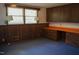 Bedroom with blue carpet, wood paneling, wall lamps, and built in desk area at 1307 Sycamore Dr, Garner, NC 27529