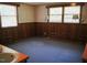Retro bedroom with blue carpet, wood paneling, and unique wall lamps at 1307 Sycamore Dr, Garner, NC 27529