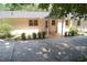 Brick home exterior with a covered porch, surrounded by lush greenery and a concrete driveway at 1307 Sycamore Dr, Garner, NC 27529