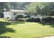 Landscaped front yard, features lush green lawn and trimmed hedges accenting a one story house at 1307 Sycamore Dr, Garner, NC 27529