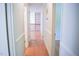 Hallway with hard wood floors leading to a kitchen with white cabinets at 1307 Sycamore Dr, Garner, NC 27529
