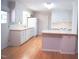 Bright kitchen featuring wood floors, white cabinets, a breakfast bar, and modern appliances at 1307 Sycamore Dr, Garner, NC 27529