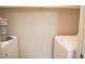 A compact laundry room with white washer and dryer and overhead storage at 1307 Sycamore Dr, Garner, NC 27529