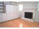 Bright living room features built-in shelving, cabinets, hardwood floors, and a charming brick fireplace at 1307 Sycamore Dr, Garner, NC 27529