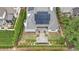 Aerial view of a private backyard featuring a patio, solar panels, lush landscaping, and a tranquil pond at 1312 Duplin Rd, Raleigh, NC 27607
