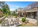 An expansive stone patio features seating, landscaping, and a solar-paneled home exterior with large sliding-glass doors at 1312 Duplin Rd, Raleigh, NC 27607