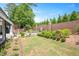 A beautifully landscaped backyard with a brick water feature, lush greenery, and a patio area at 1312 Duplin Rd, Raleigh, NC 27607