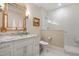 Bright bathroom featuring a marble countertop vanity with gold accents and a glass-enclosed shower with tiled walls at 1312 Duplin Rd, Raleigh, NC 27607