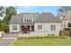Beautifully landscaped white brick home boasts lush lawn and manicured landscaping at 1312 Duplin Rd, Raleigh, NC 27607