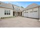 Grand white brick home featuring a three-car garage, dark wood doors, and a meticulously kept front yard at 1312 Duplin Rd, Raleigh, NC 27607