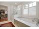 Spa-like main bathroom with a soaking tub, glass-enclosed shower, and convenient access to a walk-in closet at 1312 Duplin Rd, Raleigh, NC 27607