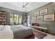 Charming main bedroom with custom bookshelves, a comfortable seating area, and tranquil views of the outdoors at 1312 Duplin Rd, Raleigh, NC 27607