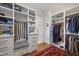 Organized walk-in closet featuring custom shelving, drawers, and a comfortable seating area with a patterned cushion at 1312 Duplin Rd, Raleigh, NC 27607