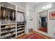 Spacious walk-in closet with custom shelving, hardwood floors and a large mirror reflecting an organized wardrobe at 1312 Duplin Rd, Raleigh, NC 27607