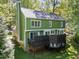 Rear elevation of home with green siding, white trim, large deck, and manicured lawn at 1408 Bridgeport Dr, Raleigh, NC 27615