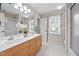 Bright bathroom with double vanity, a large mirror, a shower, and a view outside the window at 1412 Kings Lassiter Way, Raleigh, NC 27614