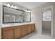 Bright bathroom with a double sink vanity, large mirror, and a doorway to an adjoining room at 1412 Kings Lassiter Way, Raleigh, NC 27614