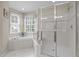Bathroom featuring a glass enclosed shower and a jacuzzi tub under a large window at 1412 Kings Lassiter Way, Raleigh, NC 27614