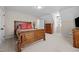 Bedroom featuring neutral walls, carpet, a wooden bedframe, a dresser, and two closets at 1412 Kings Lassiter Way, Raleigh, NC 27614