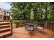 Outdoor deck with a table and chairs for dining and seating near stairs and grass at 1412 Kings Lassiter Way, Raleigh, NC 27614